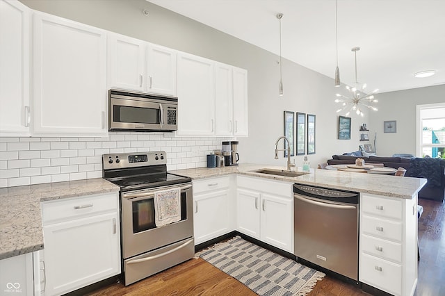 kitchen featuring white cabinetry, kitchen peninsula, sink, stainless steel appliances, and dark hardwood / wood-style flooring