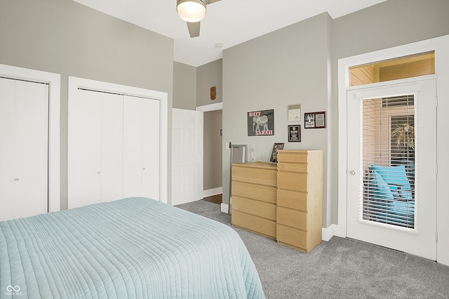 carpeted bedroom featuring access to exterior, two closets, and ceiling fan