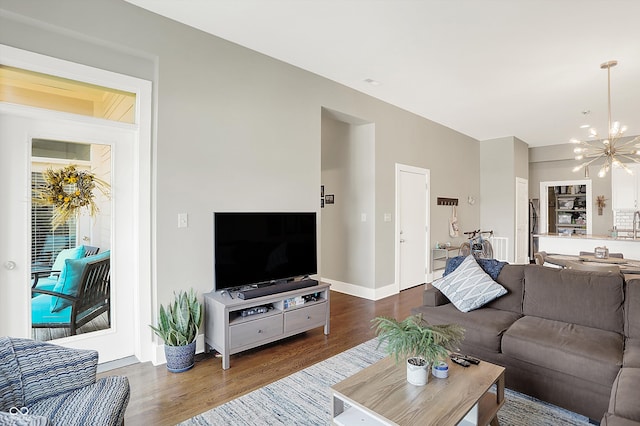 living room with a notable chandelier and dark hardwood / wood-style floors