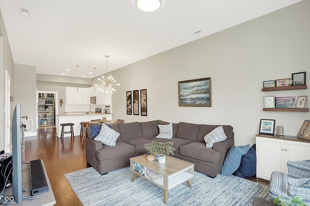 living room with hardwood / wood-style floors and an inviting chandelier