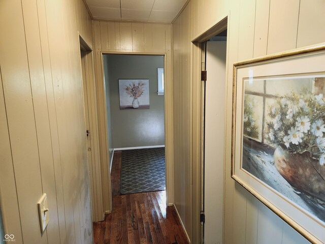 hall featuring wooden walls and dark hardwood / wood-style floors