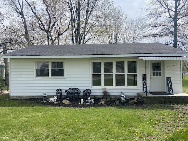 ranch-style home with a shingled roof and a front yard