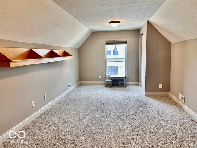 bonus room with carpet floors, a textured ceiling, and vaulted ceiling