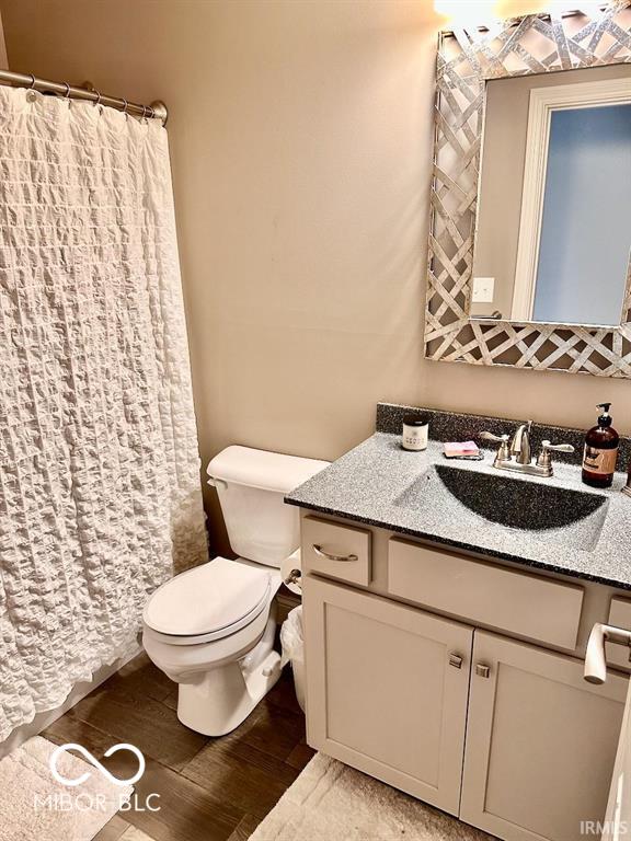 bathroom featuring hardwood / wood-style flooring, vanity, and toilet