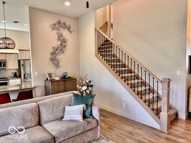 living room with a towering ceiling and light hardwood / wood-style floors