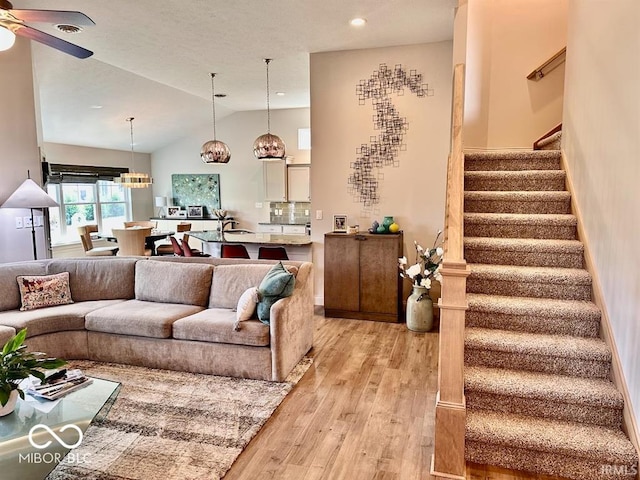 living room featuring ceiling fan, light hardwood / wood-style flooring, and high vaulted ceiling