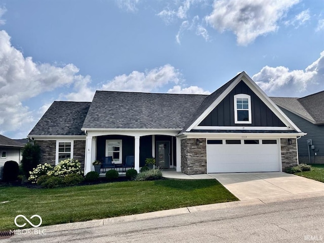 view of front of house featuring a front lawn, a porch, and a garage