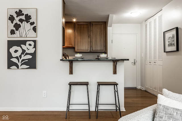 kitchen featuring a breakfast bar area and dark hardwood / wood-style flooring