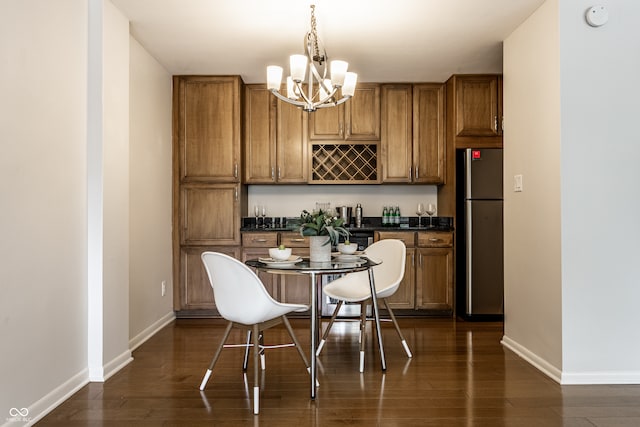 kitchen with pendant lighting, dark hardwood / wood-style flooring, an inviting chandelier, and stainless steel refrigerator