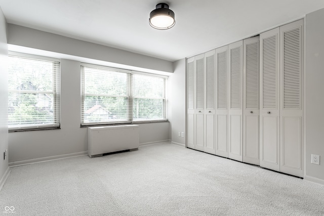 unfurnished bedroom with light carpet and a closet