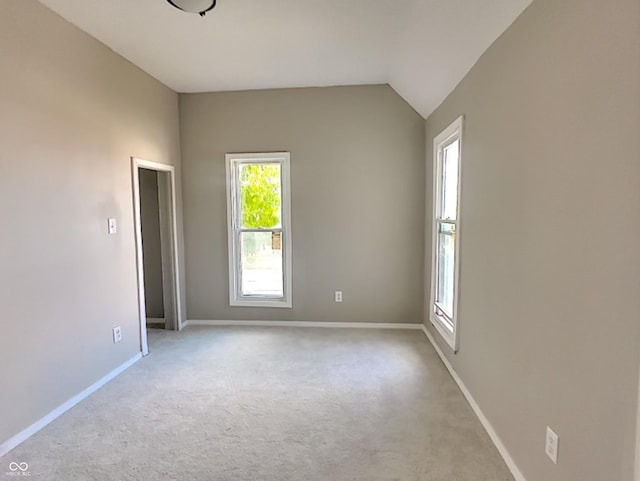 empty room featuring light carpet and vaulted ceiling