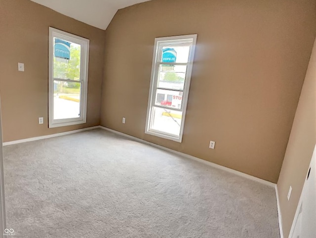 empty room with light carpet and vaulted ceiling