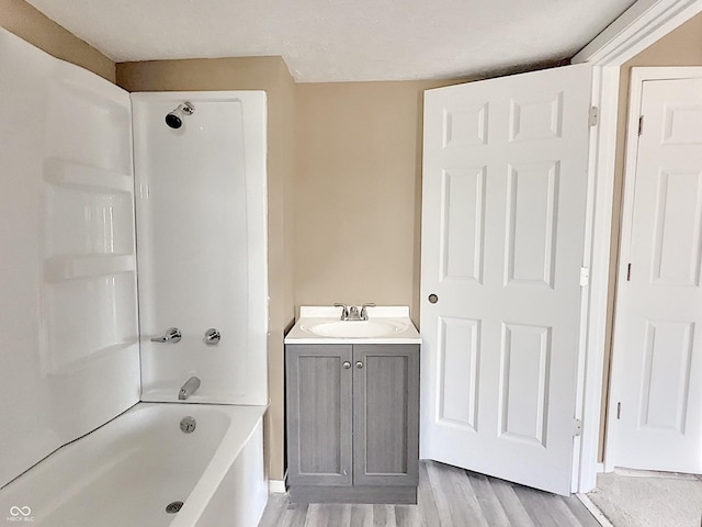 bathroom with shower / bathtub combination, hardwood / wood-style floors, and vanity