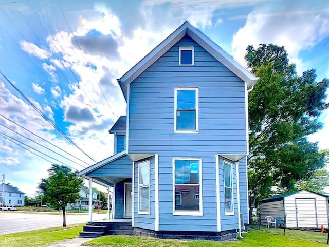 exterior space with a porch, a shed, and a lawn