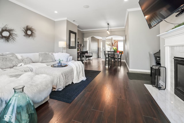 bedroom featuring decorative columns, ornamental molding, dark hardwood / wood-style flooring, and a high end fireplace