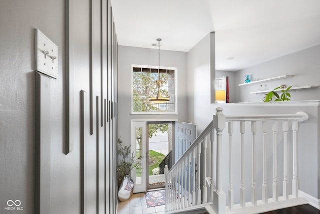 staircase with tile patterned floors and plenty of natural light