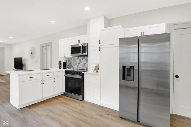 kitchen featuring decorative backsplash, white cabinetry, light hardwood / wood-style floors, kitchen peninsula, and stainless steel appliances