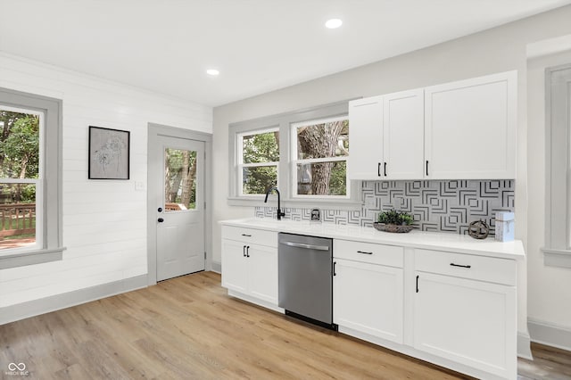 kitchen featuring dishwasher, light hardwood / wood-style floors, a healthy amount of sunlight, and white cabinets