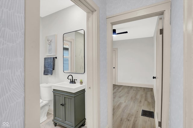 bathroom featuring vanity, hardwood / wood-style floors, and toilet