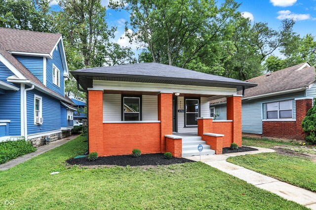 bungalow-style home with a porch and a front lawn