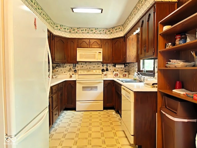 kitchen featuring white appliances, sink, and light tile patterned floors