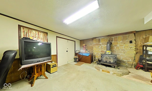 carpeted living room with a wood stove and a textured ceiling