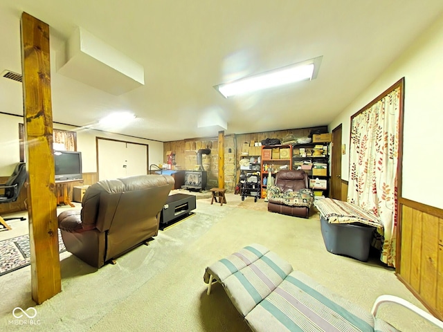 interior space with wood walls, a wood stove, and carpet