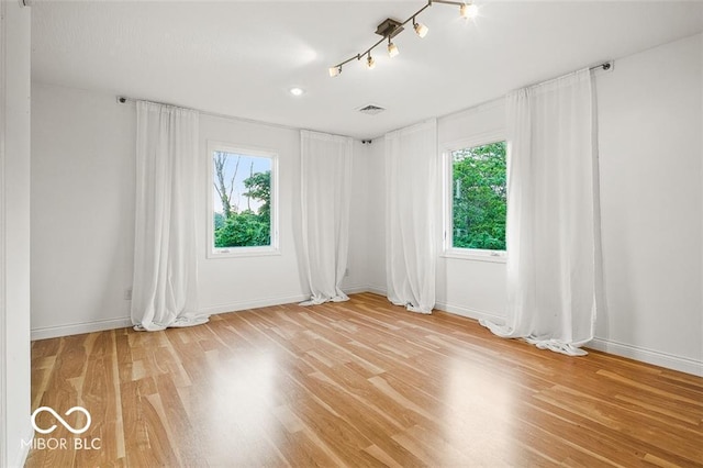 spare room featuring a healthy amount of sunlight and hardwood / wood-style floors