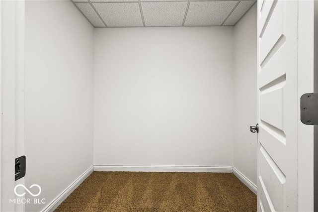 empty room featuring carpet and a paneled ceiling