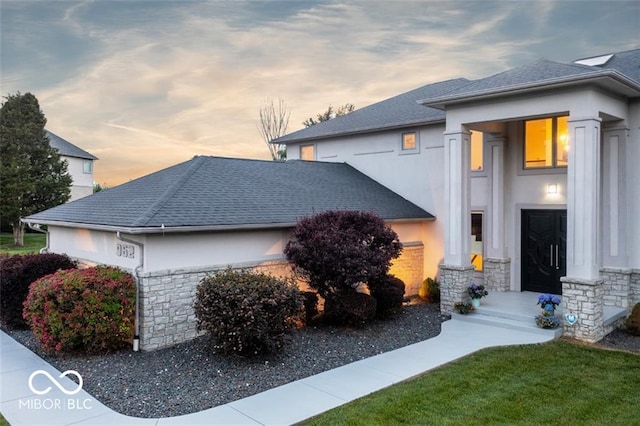 property exterior at dusk with a lawn