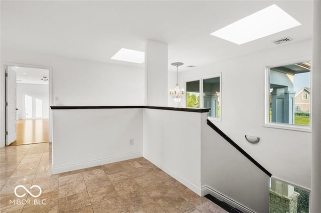 interior space featuring a skylight and a chandelier