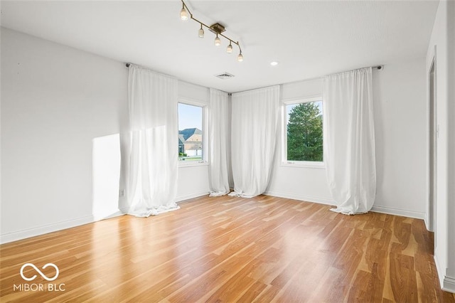 spare room featuring hardwood / wood-style floors and a wealth of natural light