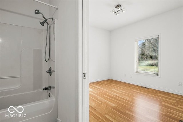 bathroom featuring bathing tub / shower combination and hardwood / wood-style floors