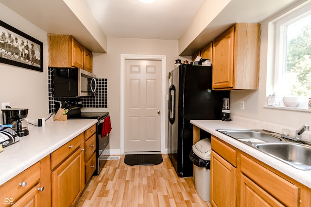 kitchen featuring tasteful backsplash, electric range oven, sink, and light hardwood / wood-style floors