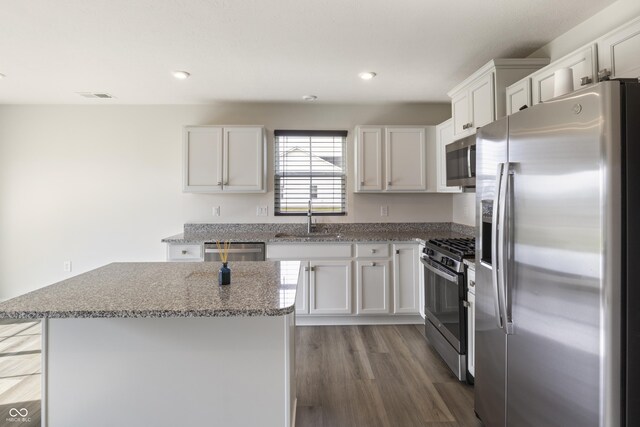 kitchen featuring sink, a center island, light wood-type flooring, stainless steel appliances, and white cabinets