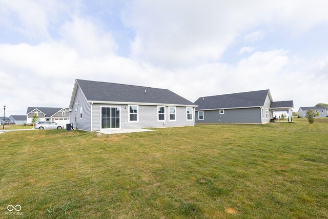 rear view of property featuring a patio and a lawn