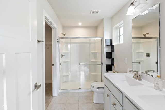 bathroom with tile patterned flooring, toilet, an enclosed shower, and vanity