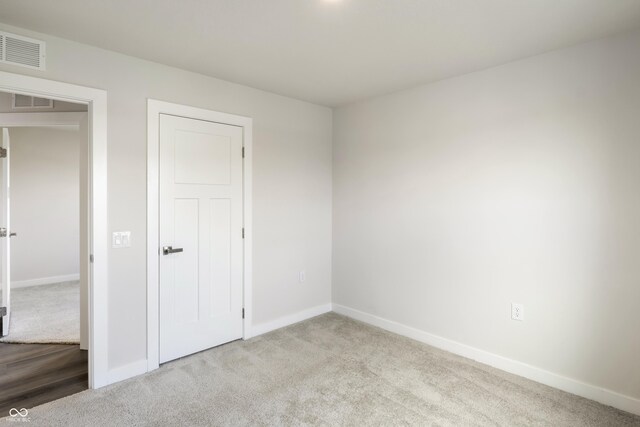 unfurnished bedroom with light colored carpet