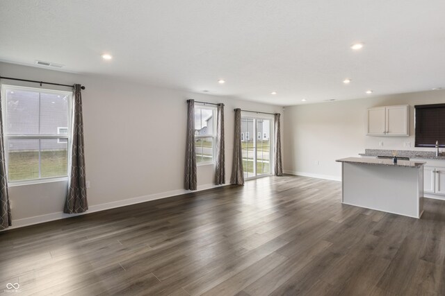 unfurnished living room with dark wood-type flooring