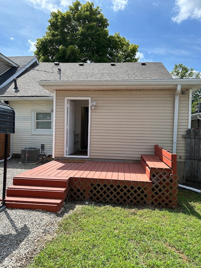 rear view of house featuring a lawn, a deck, and central AC