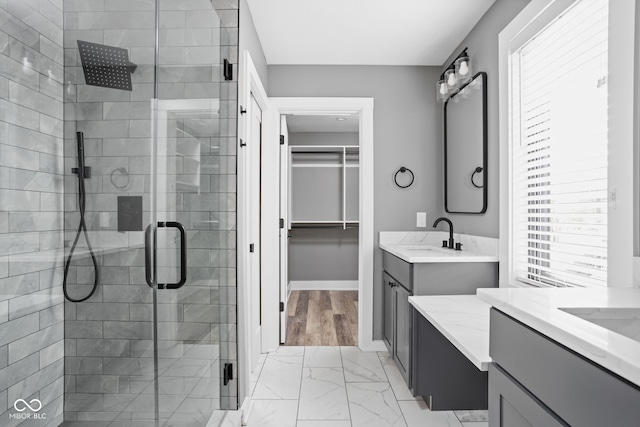 bathroom featuring vanity, a healthy amount of sunlight, hardwood / wood-style flooring, and walk in shower