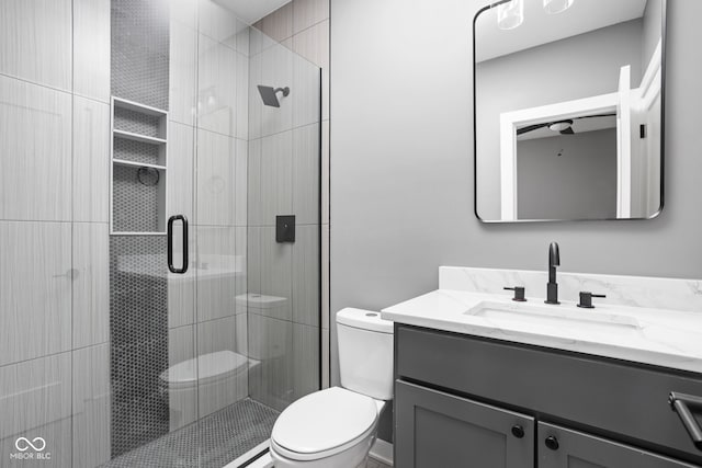 bathroom with vanity, toilet, and a shower with shower door