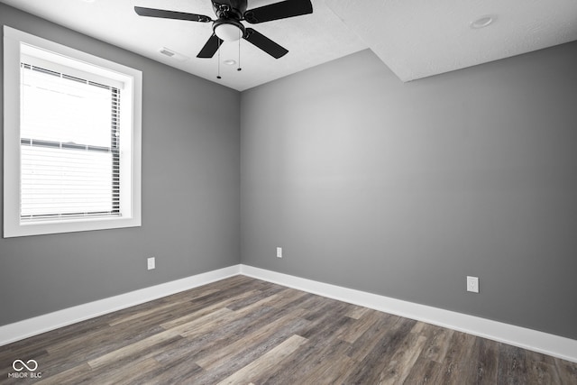 unfurnished room featuring a textured ceiling, ceiling fan, and dark hardwood / wood-style flooring