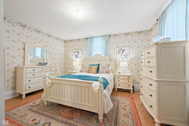 bedroom featuring a textured ceiling and light hardwood / wood-style flooring