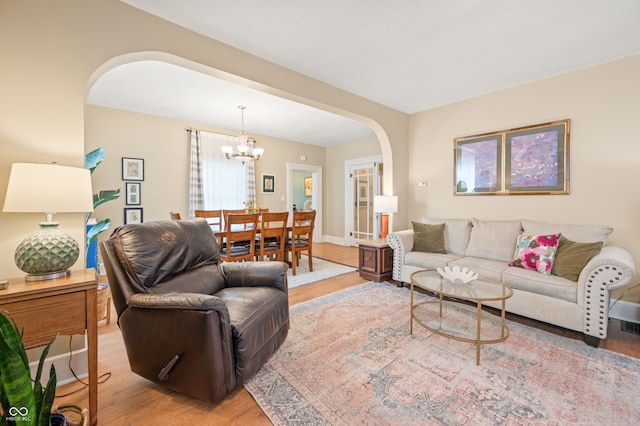 living room with light hardwood / wood-style floors and a chandelier