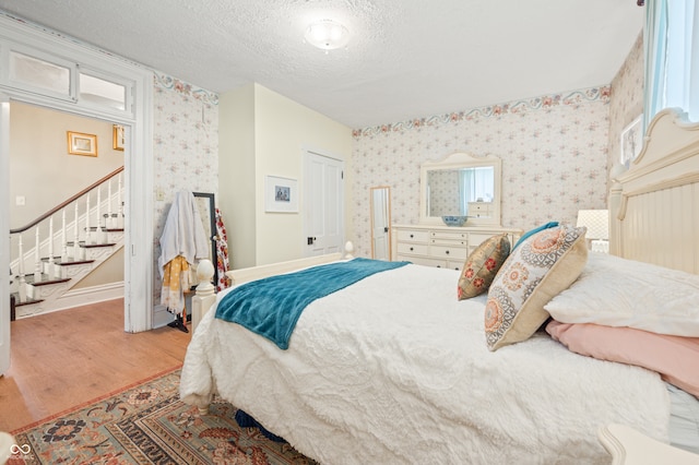 bedroom with light wood-type flooring and a textured ceiling