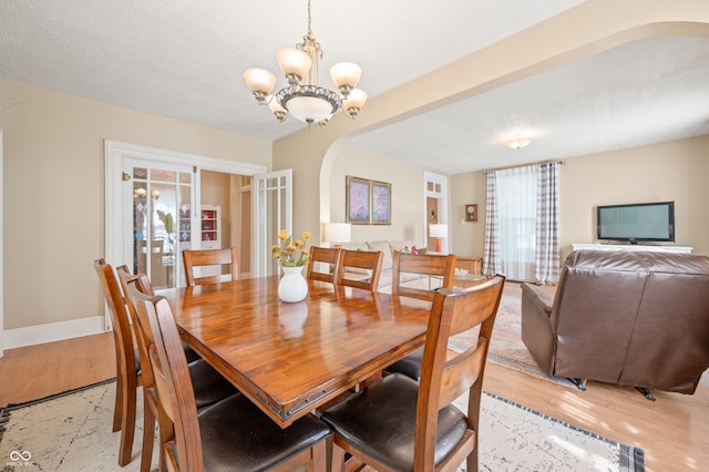 dining room with light hardwood / wood-style flooring and an inviting chandelier