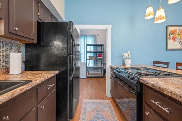 kitchen with decorative backsplash, light wood-type flooring, dark brown cabinetry, hanging light fixtures, and black appliances