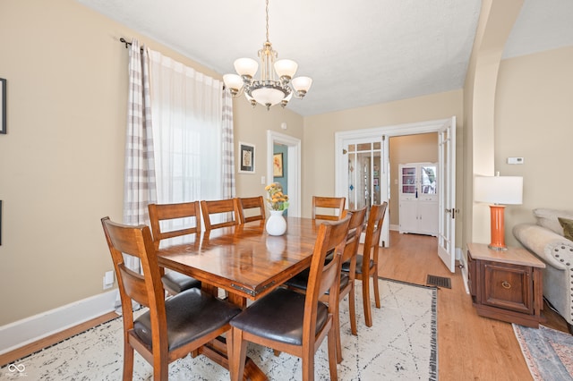 dining room with an inviting chandelier and light wood-type flooring