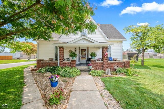 bungalow with a front lawn and a porch